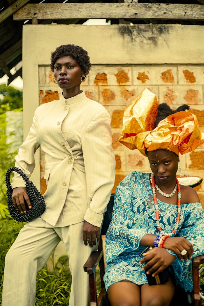 service-02 Stylish portrait of two adults in vibrant traditional African attire outdoors.